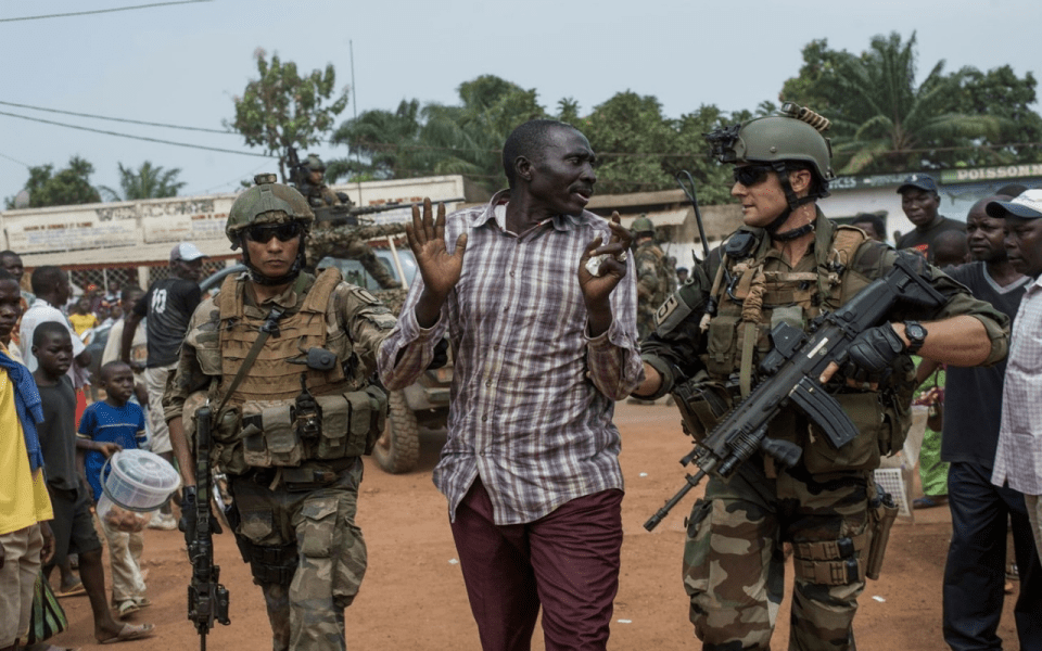 French soldiers holding an african man
